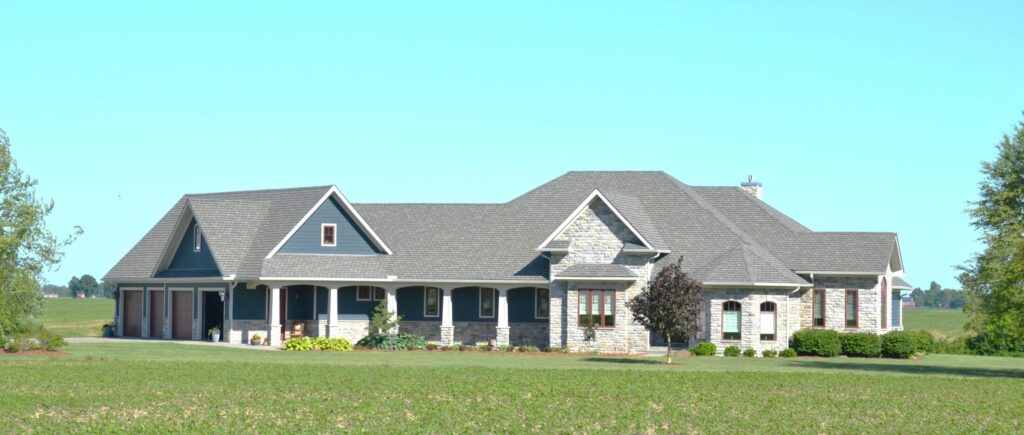 large modern house with gray roof in a green field