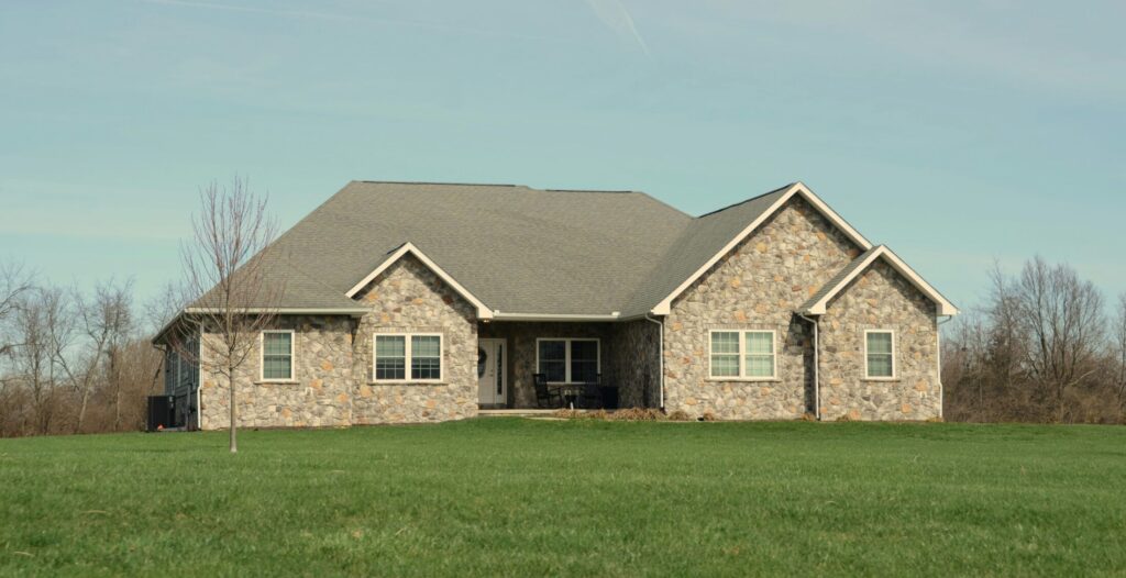 a large stone house with a green lawn